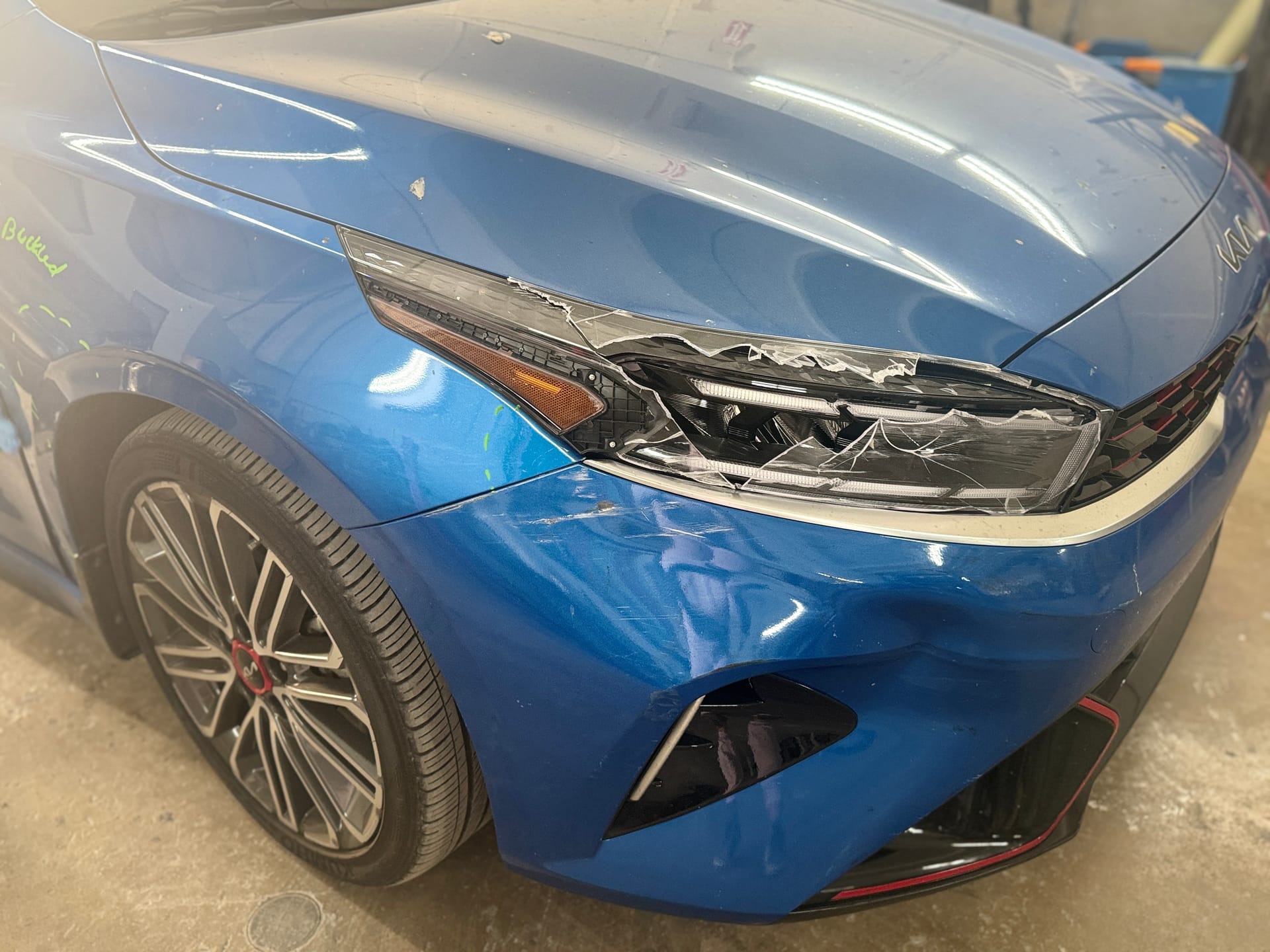 Kia Forte GT with a cracked front bumper and broken headlight