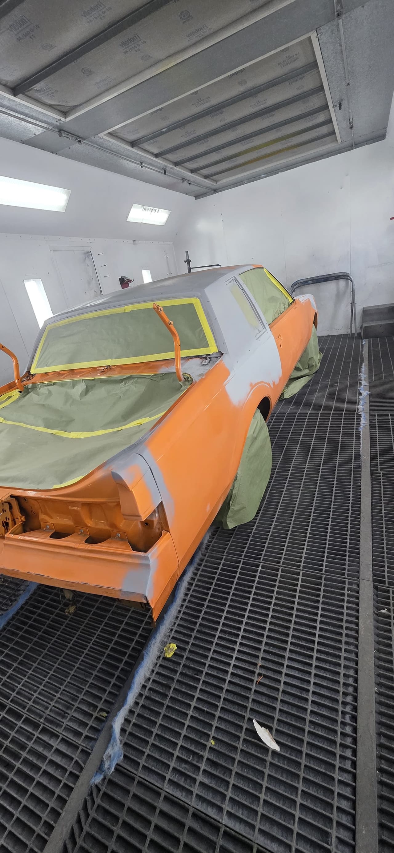 Classic Chevy Malibu in primer, masked inside the KAG paint booth