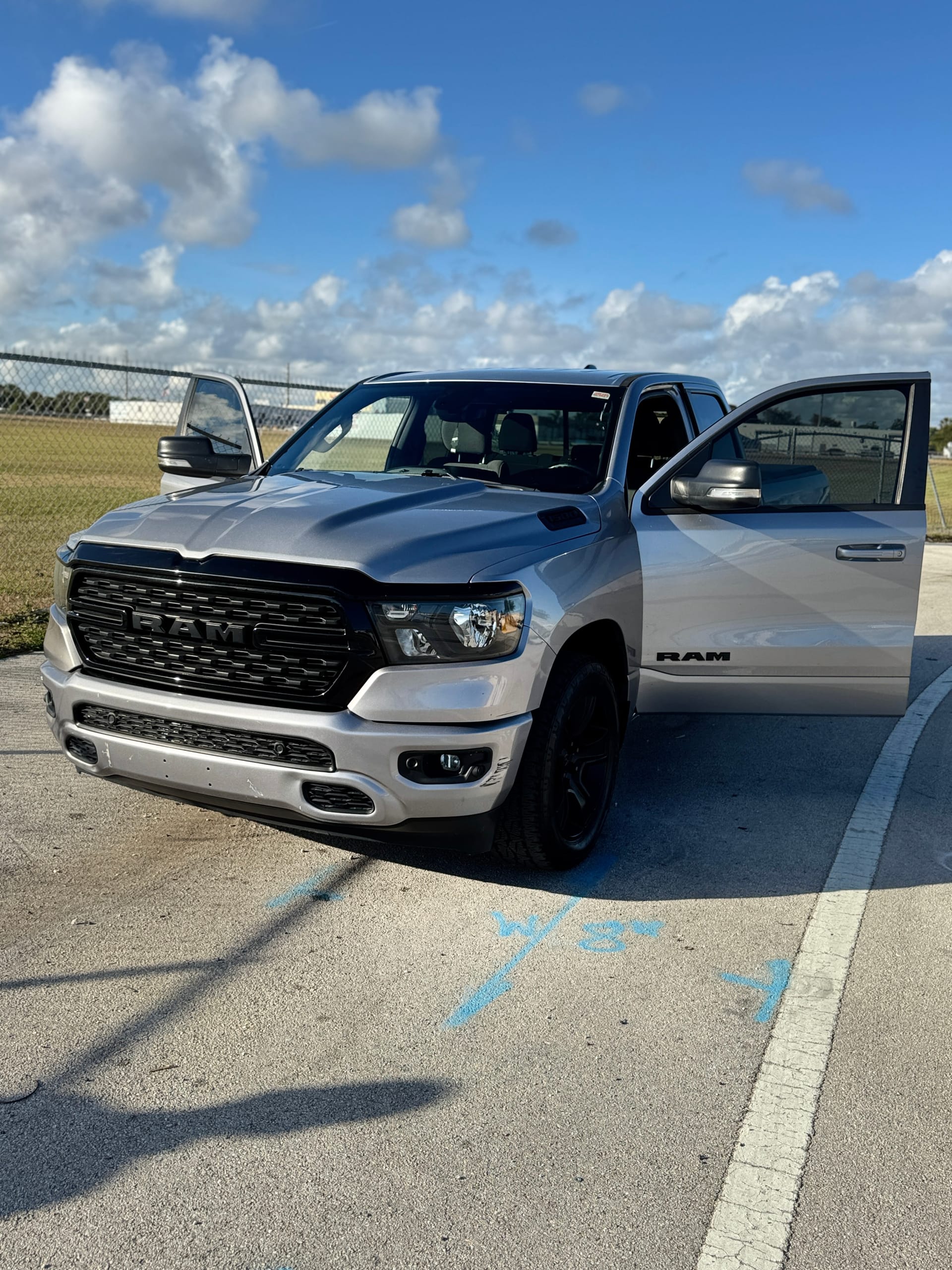 Silver Ram 1500 with a finished front end, doors open, outside the shop