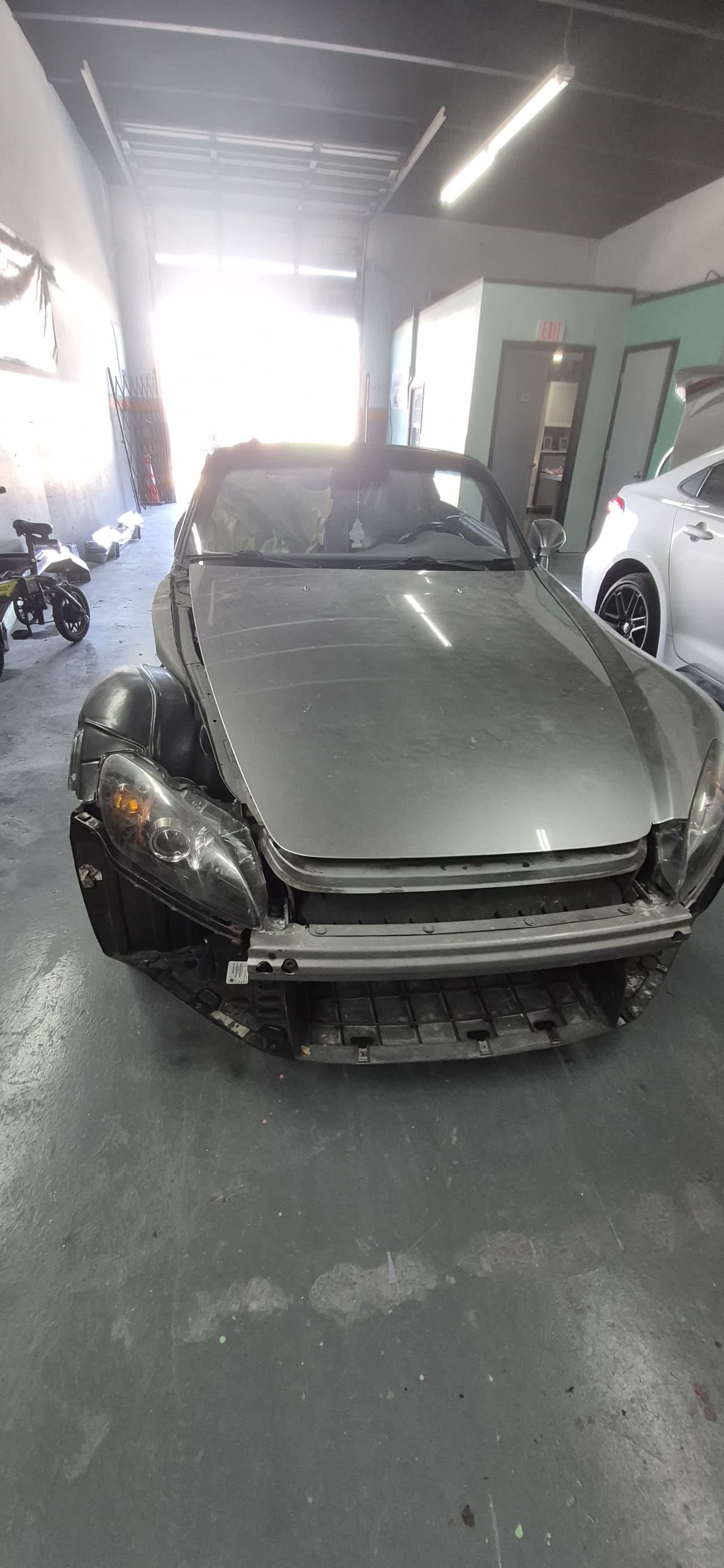 Silver roadster with the front bumper removed after a collision